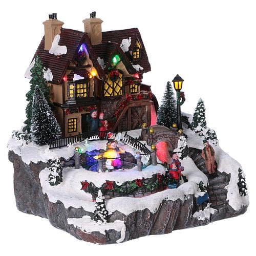 Scena animata per villaggio di Natale con pista da pattinaggio e cascata h 27 cm - 2