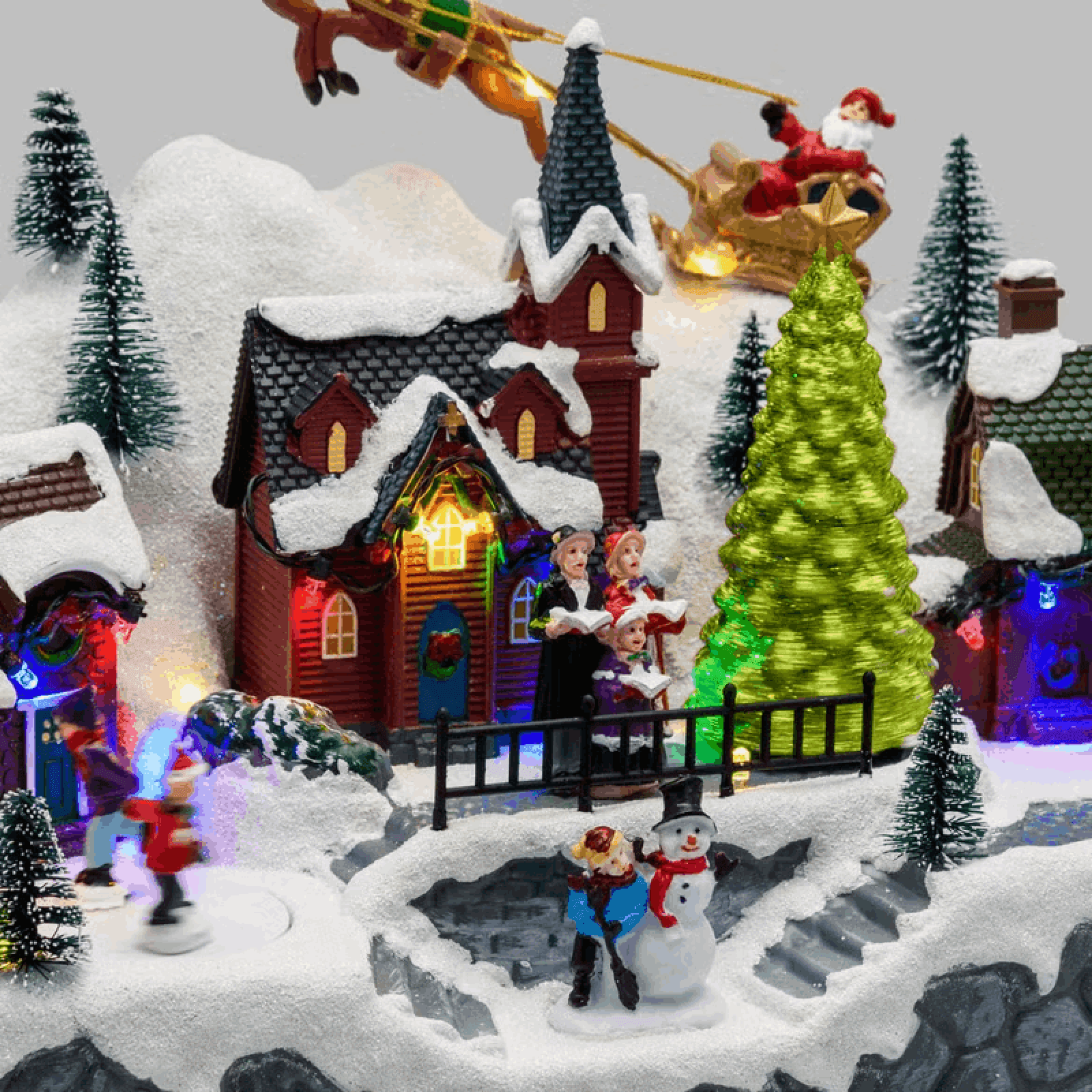 Paesaggio natalizio con Babbo Natale su slitta volante e pattinatori in movimento, led multicolor - 3