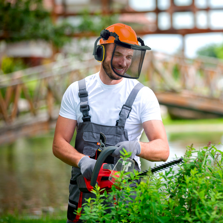 Elmetto protettivo con visiera a rete e cuffie antirumore