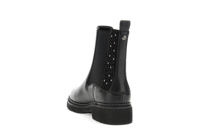 TRONCHETTO IN SINTETICO EFFETTO PELLE CON ELASTICO E INSERTI DI STRASS E BORCHIE