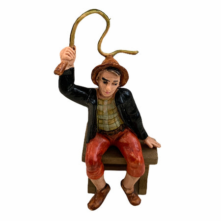 Statuetta per presepe natalizio uomo seduto con una frusta lucida h 7 cm