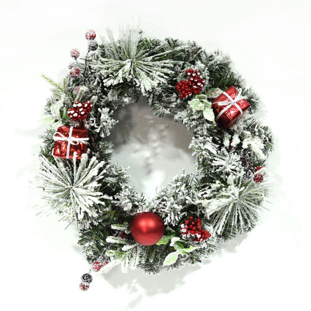 Ghirlanda tonda innevata corona dietro porta con bacche e palline