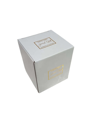 Candela in vetro ambra con forma bon bon e nappina decorativa, firmata Special Gifts, altezza 11 cm, diametro 8 cm, con scatola regalo.