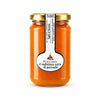 Un barattolo di vetro con confettura extra di percoche arancione vivace da 300 gr con etichetta bianca elegante e coperchio oro