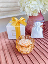 Candela profumata in vetro ambra con forma a fiore, firmata Special Gifts, altezza 6 cm, diametro 8 cm, completa di scatola regalo elegante.