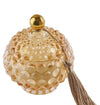 Candela in vetro ambra con forma bon bon e nappina decorativa, firmata Special Gifts, altezza 11 cm, diametro 8 cm, con scatola regalo.