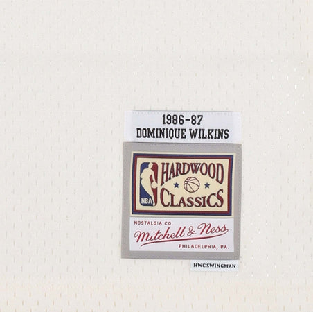 MITCHELL-&amp;-NESS-Canotta-Basket-Uomo-Nba-Off-White-Team-Color-Swingman-Jersey-Hardwood-Classics-1986-No-21-Dominique-Wilkins-Atlhaw-Off-White-da-uomo