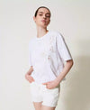 T-shirt Twinset donna in cotone bianco con ricamo ad intarsio e spalle scese indossata