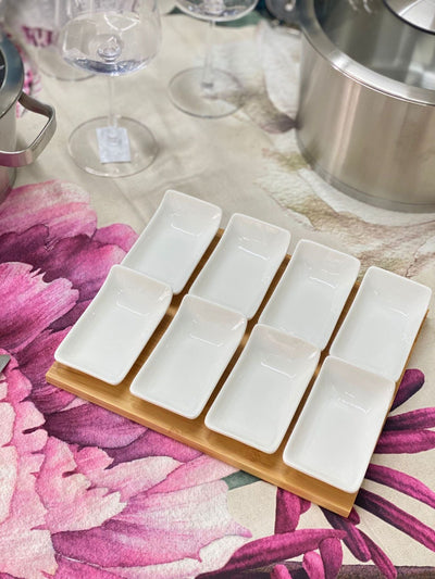 Antipastiera con 8 ciotole in porcellana bianca su base in legno, dimensioni 25x20 cm, perfetta per servire antipasti e snack con eleganza.